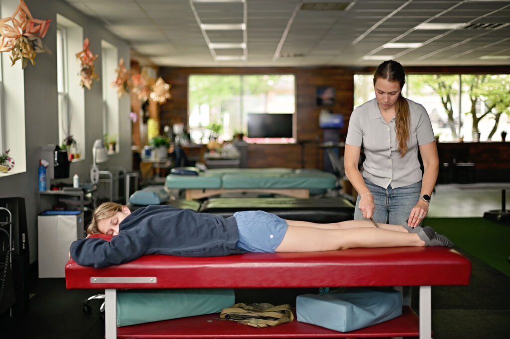 Dr. Chloe providing manual physical therapy before strength training