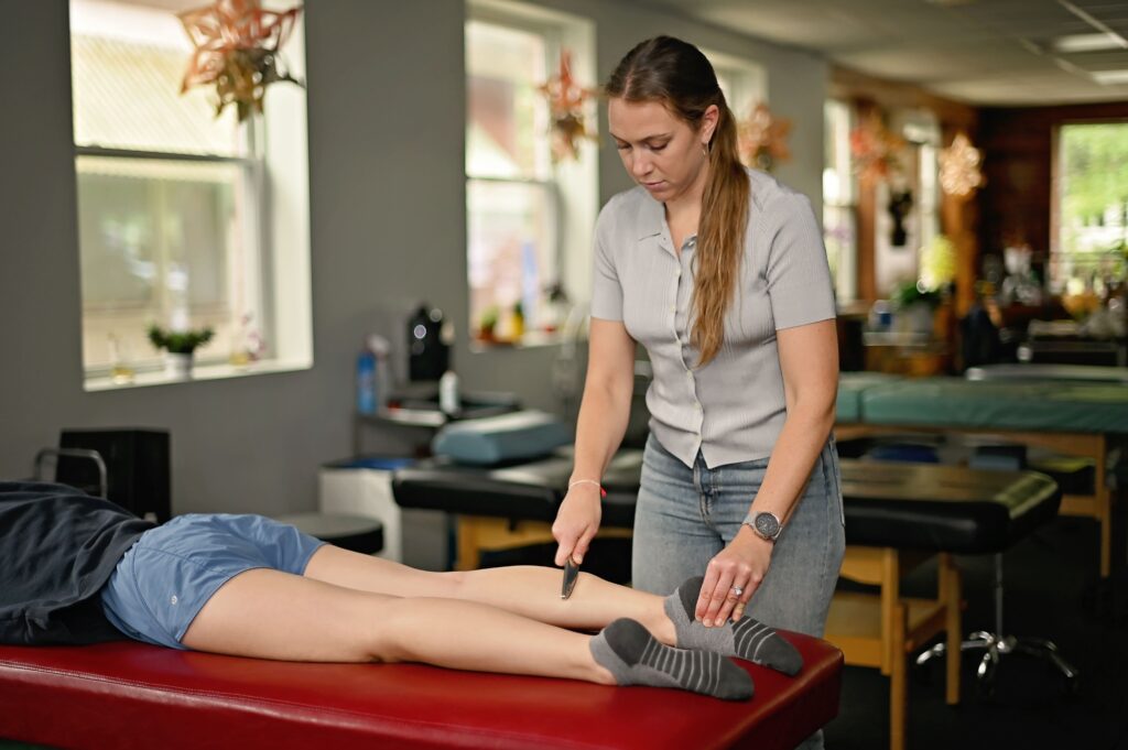 chloe performing graston - a type of soft tissue physical therapy