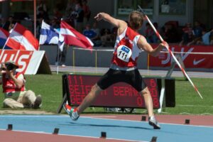 a boy about to throw a javelin out of his right hand. the hand is pulled back ready to spring forward demonstrating the mobility needed for throwing