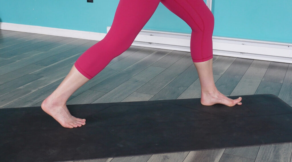 Dr. Chloe with her feet in a split squat position (left in front) with her big toe raised in a toe yoga hold