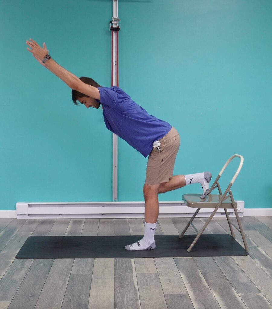 Dr. Jon demonstrating the variation where he has classic rear foot elevated rdl position but his arms are straight elbows by his ears.