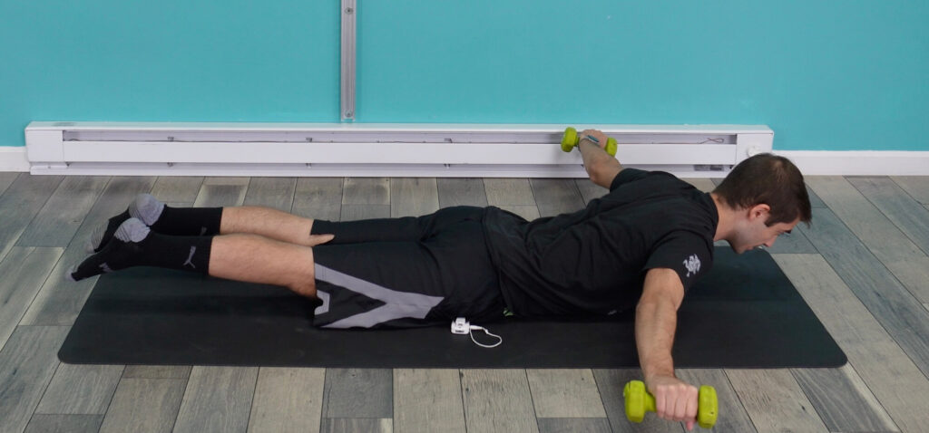 Dr. Jon doing the prone arm sweeps with his hands out in a T position showing the midway point of the sweep