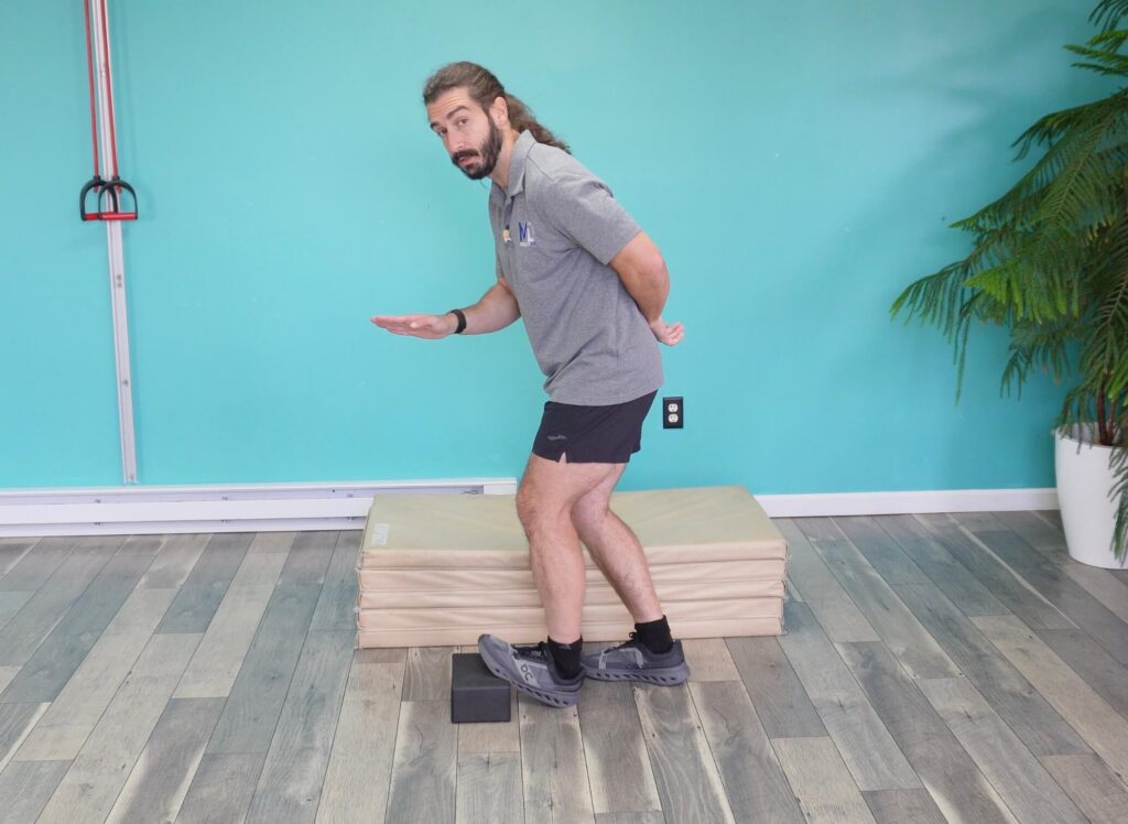 Dr. John demonstrating the bent knee version with his knee bent while keeping his toes up on the yoga block