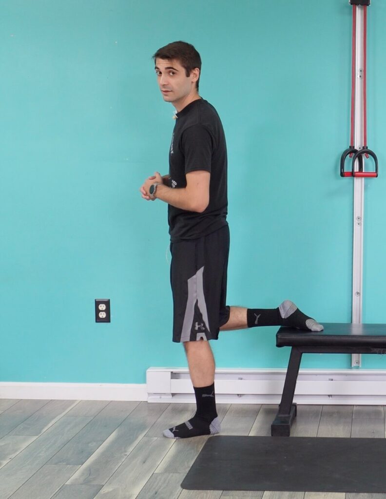 Dr. Jon demonstrating the foot placement of the bulgarian split squat with the back leg's toes turned flat