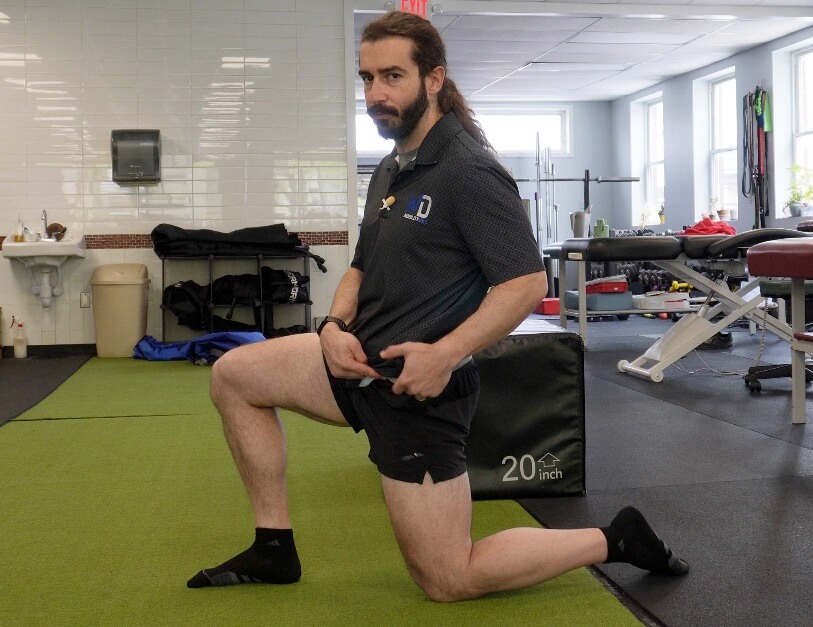 Dr. John with his left knee on the ground right foot on the ground in a hip flexor stretch