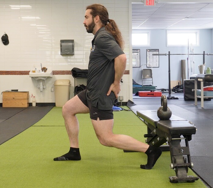 Dr. John in a split squat holding isometrically to improve tendon health